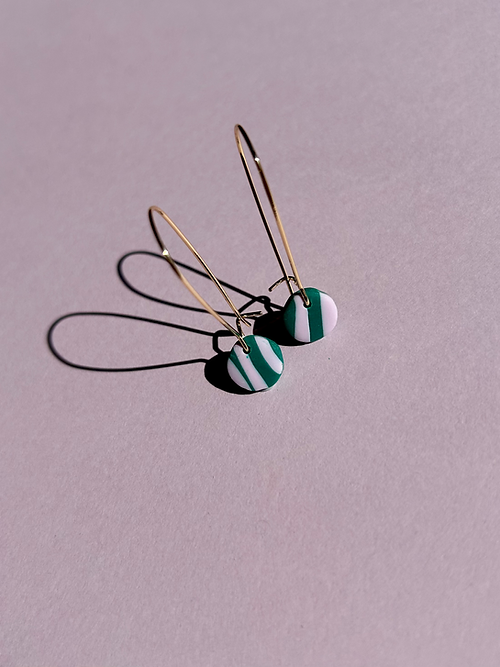 24k Gold Plated Mini Pink & Green Wavy Oval Hoops featuring delicate 30mm oval hoops with 9mm striped clay discs in green and pastel pink, casting elegant shadows on pink background. By Aloe Earrings - Jewellery, Gifts Under £15, Gifts under £20, Earrings, Face, Aloe Earrings