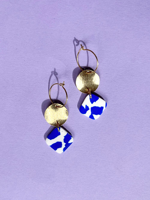 24k Gold Plated Blue & White Terrazzo Drop Hoops featuring delicate wire hoops with brushed gold disc and blue-white speckled terrazzo clay diamond drops, casting artistic shadows on lilac background - by Aloe Earrings - Jewellery, Gifts under £20, Earrings, Face, Aloe Earrings collection