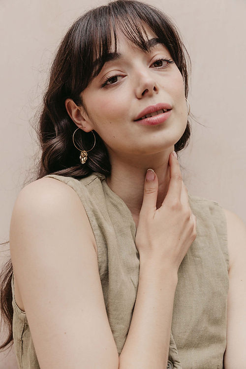 24k Gold Plated Big Hammered Brass Hoops elegantly displayed on model wearing neutral linen top, showcasing the 35mm dimensional design and textured hammered finish. By Aloë Earrings - Collections: Jewellery, Gifts Under £15, Gifts under £20, Earrings, Face, Aloe Earrings