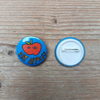 6049f0ff45e42d1cbc99c46b_eat-apples-badge-front-and-back_1760703786111.png
