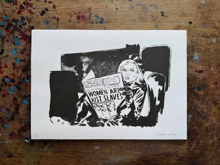 Illustration of a woman reading a newspaper with a sign 'Women are just slaves' on a wooden surface.