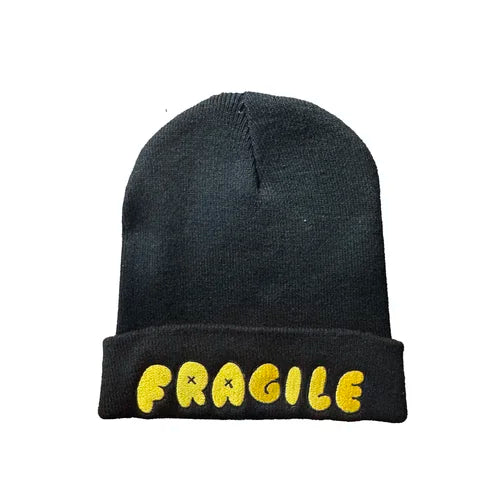 a black beanie hat with the word fragile in yellow bubble writing
